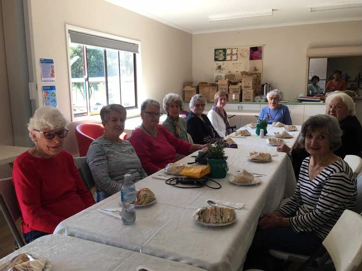 Locals sitting down together at a community lunch inside the Centre